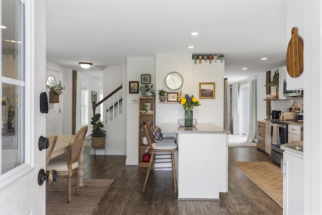140 New Meadows Rd, West Bath, ME 04530 - kitchen featuring stainless steel appliances, a kitchen breakfast bar, dark wood-style floors, white cabinets, and light stone counters