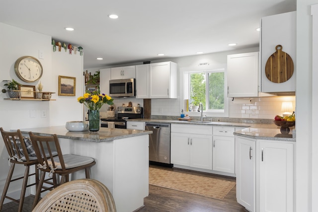 140 New Meadows Rd, West Bath, ME 04530 - kitchen with stainless steel appliances, dark wood-type flooring, a breakfast bar, backsplash, and recessed lighting