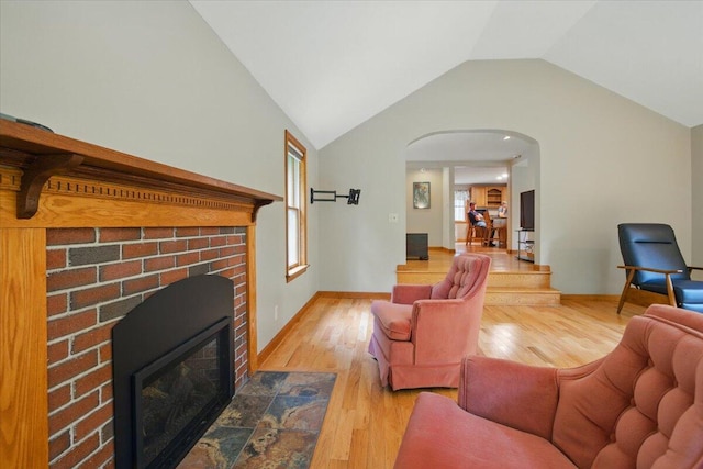 463 Cobbs Bridge Rd, New Gloucester, ME 04260 - living area featuring arched walkways, wood finished floors, a brick fireplace, and lofted ceiling