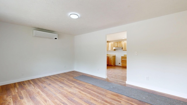1 Barker St, Jay, ME 04239 - empty room with a wall mounted AC, light wood-style floors, and baseboards