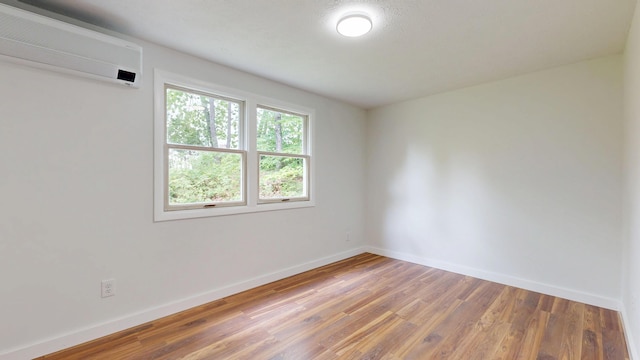 1 Barker St, Jay, ME 04239 - spare room featuring a wall mounted air conditioner and wood finished floors