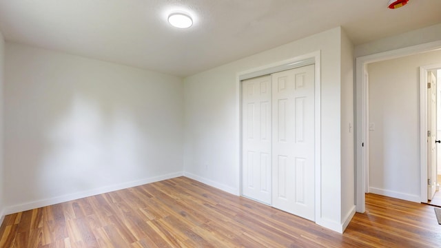 1 Barker St, Jay, ME 04239 - unfurnished bedroom with wood finished floors, baseboards, and a closet