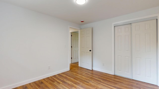 1 Barker St, Jay, ME 04239 - unfurnished bedroom with baseboards, light wood finished floors, and a closet