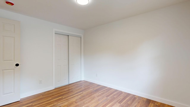 1 Barker St, Jay, ME 04239 - unfurnished bedroom featuring baseboards, light wood-style flooring, and a closet