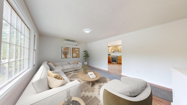 1 Barker St, Jay, ME 04239 - living area featuring a wall mounted AC, light wood finished floors, and a textured ceiling