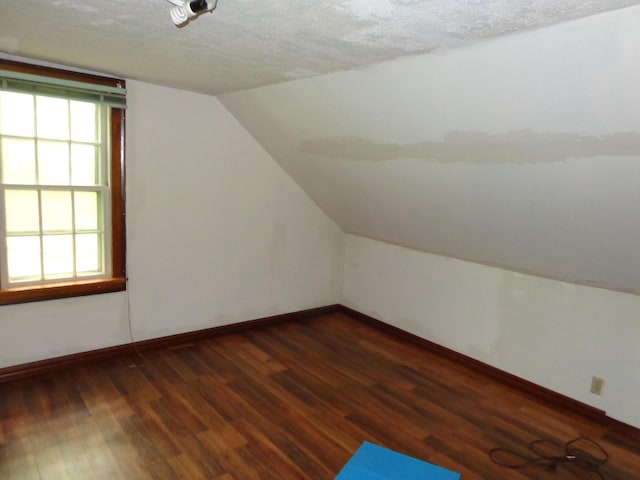 27 Grove St, Sanford, ME 04083 - additional living space featuring lofted ceiling, dark wood-style floors, and a textured ceiling