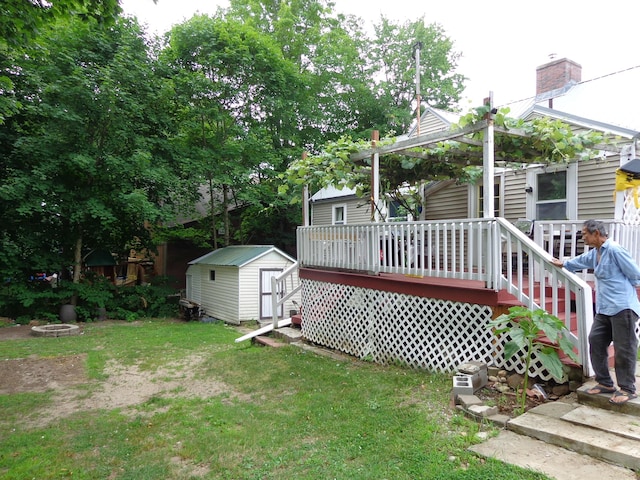 27 Grove St, Sanford, ME 04083 - view of grassy yard with a shed, a wooden deck, and an outdoor fire pit