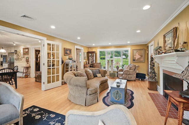 4 Mayflower Rd, Hallowell, ME 04347 - living area featuring french doors, light wood-style floors, ornamental molding, recessed lighting, and a fireplace with flush hearth