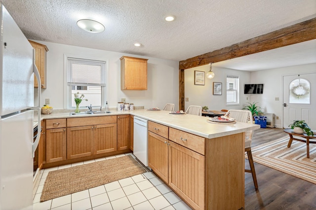 3 Ocean Breeze Unit 2, York, ME 03909 - kitchen with white appliances, a peninsula, a breakfast bar, a sink, and a textured ceiling