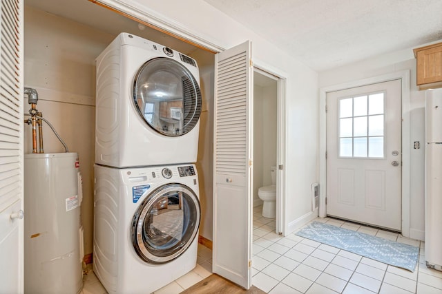 3 Ocean Breeze Unit 2, York, ME 03909 - laundry area featuring stacked washer / drying machine, water heater, light tile patterned floors, and baseboards