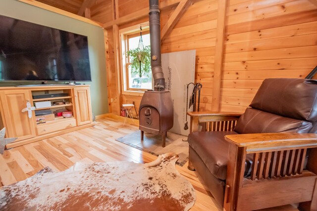 54 Carver Rd, Milo, ME 04463 - sitting room with light wood-style flooring, a wood stove, and wooden walls