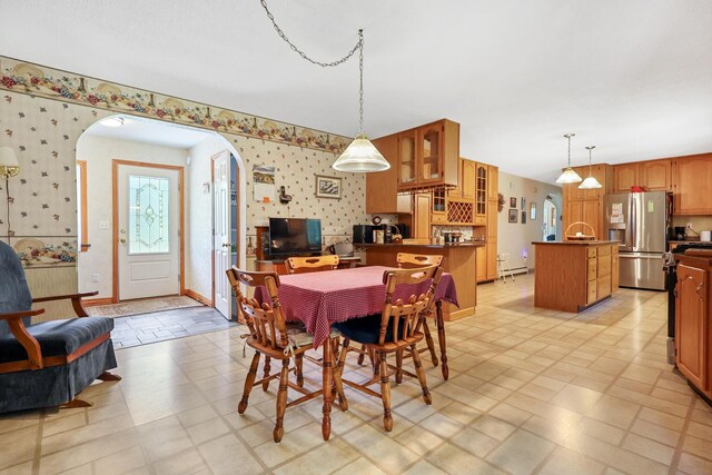 426 Fuller Rd, Carmel, ME 04419 - dining space featuring wallpapered walls, arched walkways, light flooring, and a baseboard heating unit