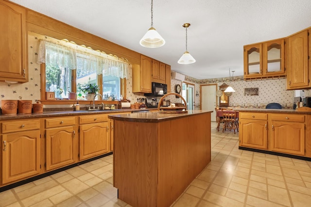 426 Fuller Rd, Carmel, ME 04419 - kitchen featuring black microwave, wallpapered walls, a kitchen island, hanging light fixtures, and dark countertops