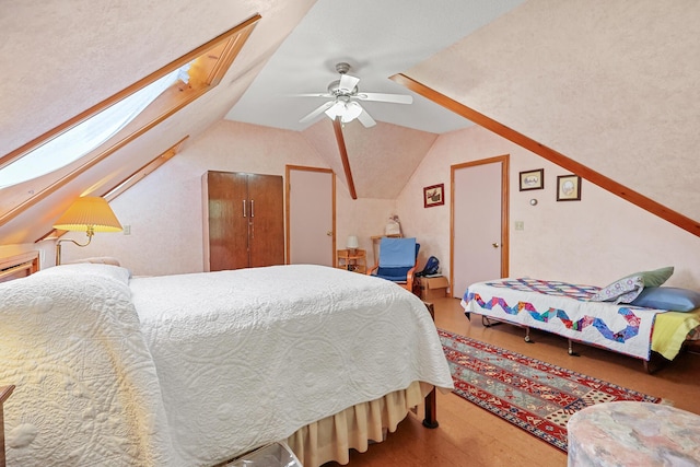 426 Fuller Rd, Carmel, ME 04419 - bedroom with wood finished floors, vaulted ceiling, a skylight, and ceiling fan