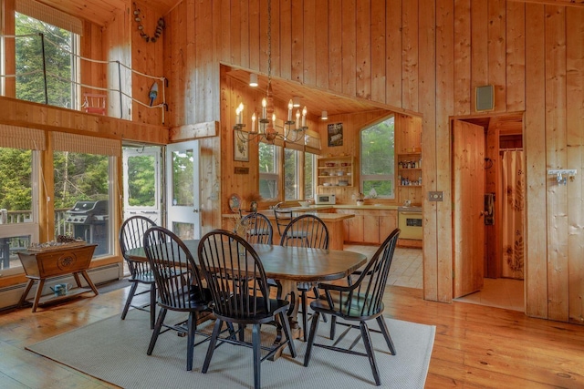 47 Eaton Point Rd, Deer Isle, ME 04627 - dining area with a high ceiling, wood walls, light wood-type flooring, and baseboard heating