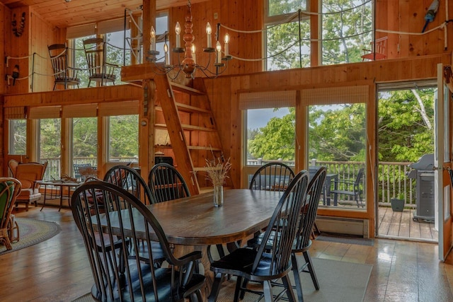 47 Eaton Point Rd, Deer Isle, ME 04627 - dining room featuring wooden walls, a towering ceiling, a chandelier, and wood-type flooring