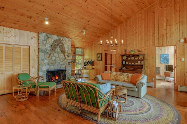 47 Eaton Point Rd, Deer Isle, ME 04627 - living room featuring hardwood / wood-style flooring, wood walls, high vaulted ceiling, a stone fireplace, and a chandelier