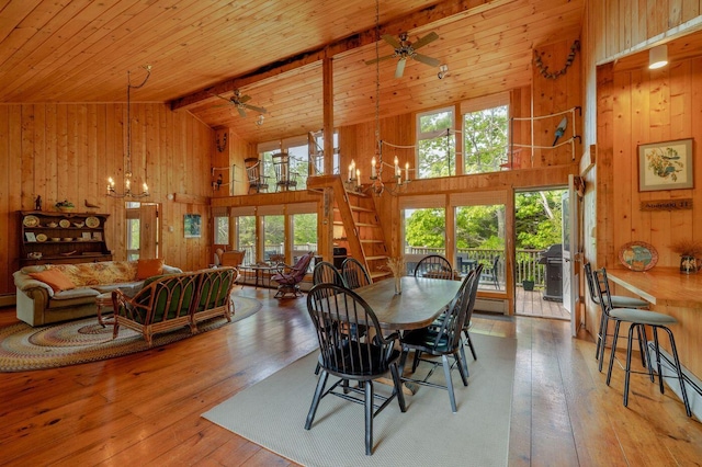 47 Eaton Point Rd, Deer Isle, ME 04627 - dining room with a chandelier, wood walls, plenty of natural light, wood-type flooring, and a ceiling fan