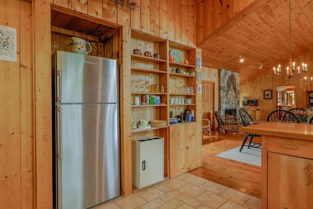 47 Eaton Point Rd, Deer Isle, ME 04627 - kitchen with freestanding refrigerator, wood walls, a chandelier, a stone fireplace, and wooden ceiling