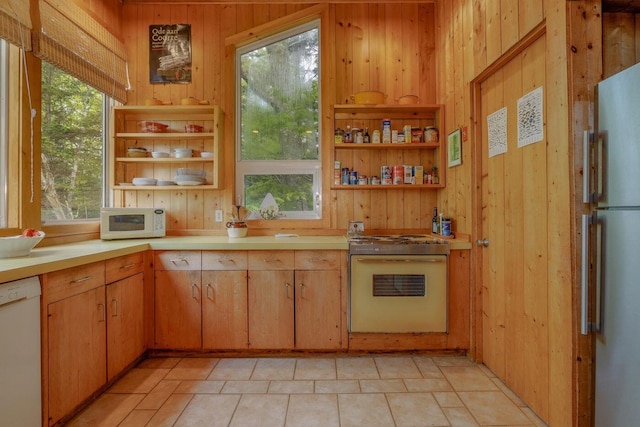 47 Eaton Point Rd, Deer Isle, ME 04627 - kitchen featuring white appliances, open shelves, wood walls, light countertops, and light tile patterned flooring