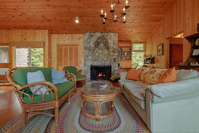 47 Eaton Point Rd, Deer Isle, ME 04627 - living area featuring wood walls, wood ceiling, a chandelier, a stone fireplace, and light wood-style floors