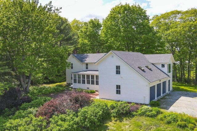 565 Bagaduce Rd, Brooksville, ME 04617 - rear view of property featuring a sunroom, roof with shingles, driveway, an attached garage, and a chimney