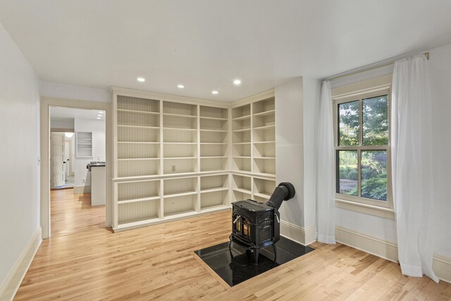 565 Bagaduce Rd, Brooksville, ME 04617 - unfurnished room featuring a wood stove, wood finished floors, baseboards, and recessed lighting