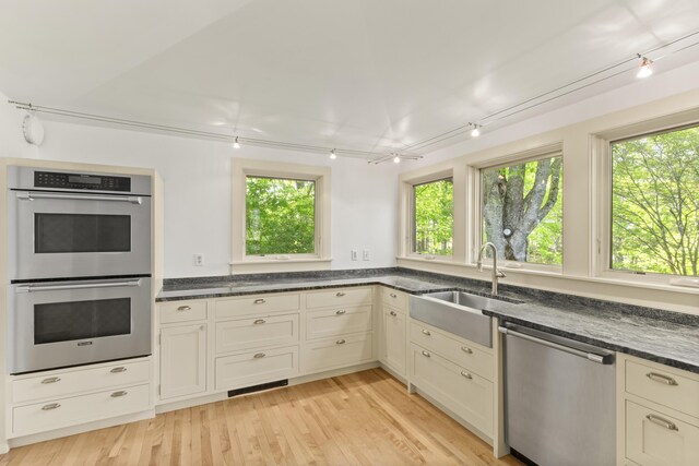 565 Bagaduce Rd, Brooksville, ME 04617 - kitchen featuring appliances with stainless steel finishes, a sink, dark stone counters, and light wood finished floors