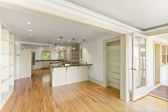 565 Bagaduce Rd, Brooksville, ME 04617 - kitchen with a peninsula, open shelves, light wood finished floors, a kitchen breakfast bar, and decorative light fixtures