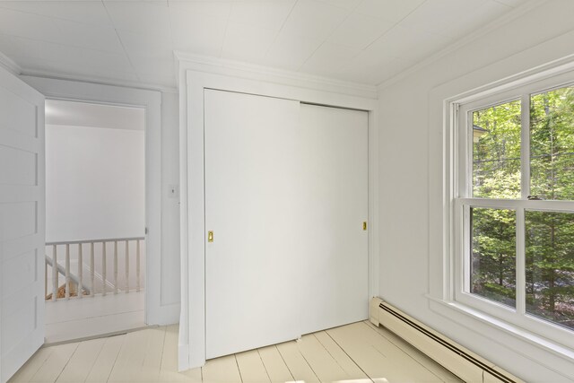 565 Bagaduce Rd, Brooksville, ME 04617 - unfurnished bedroom featuring baseboard heating, multiple windows, ornamental molding, and a closet