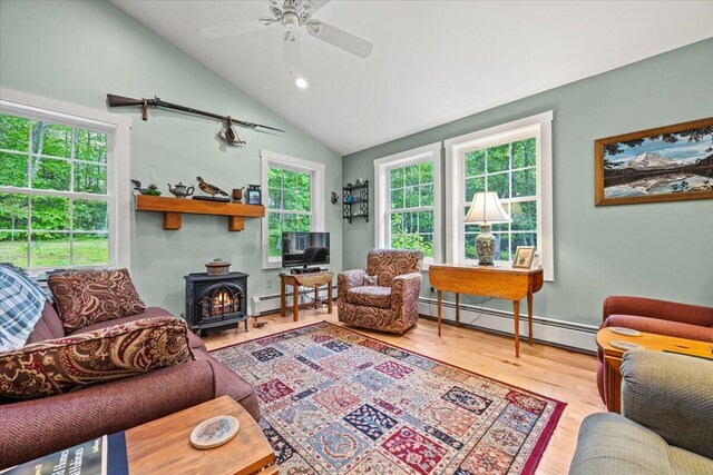 489 Shady Nook Rd, Newfield, ME 04095 - living room with a baseboard heating unit, a wood stove, wood finished floors, ceiling fan, and vaulted ceiling