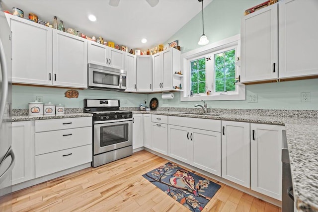 489 Shady Nook Rd, Newfield, ME 04095 - kitchen featuring appliances with stainless steel finishes, light wood-style floors, hanging light fixtures, white cabinets, and light stone countertops