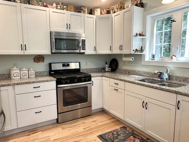 489 Shady Nook Rd, Newfield, ME 04095 - kitchen featuring appliances with stainless steel finishes, light wood finished floors, and white cabinets