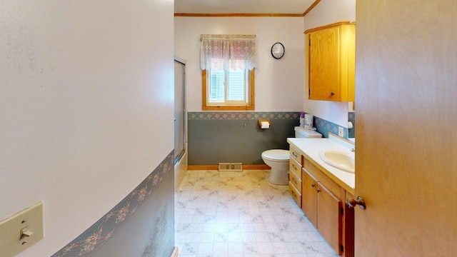 180 Bowdoin St, Millinocket, ME 04462 - bathroom with tile patterned floors, toilet, ornamental molding, vanity, and wainscoting