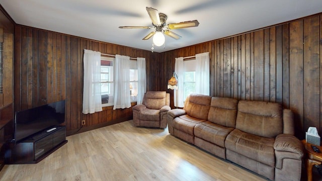 180 Bowdoin St, Millinocket, ME 04462 - living room featuring a ceiling fan, wooden walls, and light wood finished floors