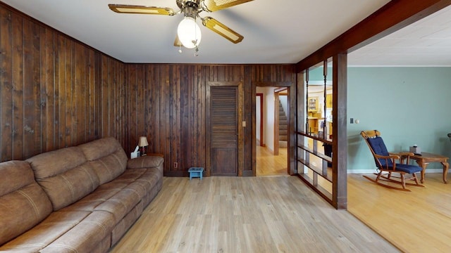 180 Bowdoin St, Millinocket, ME 04462 - living area with wood walls, light wood finished floors, stairs, a ceiling fan, and baseboards