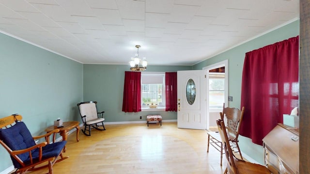 180 Bowdoin St, Millinocket, ME 04462 - foyer with ornamental molding, a chandelier, wood finished floors, and baseboards