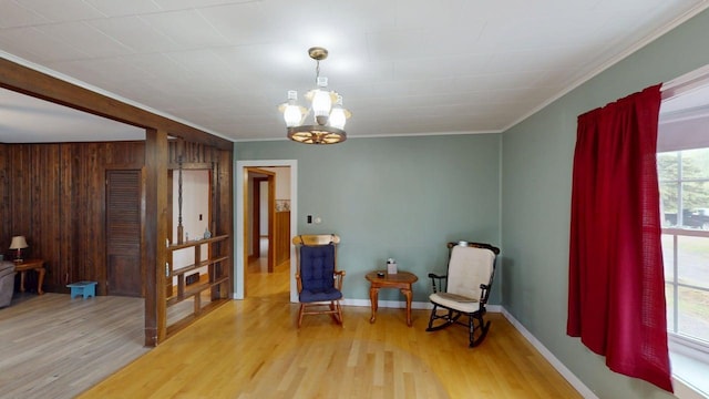 180 Bowdoin St, Millinocket, ME 04462 - sitting room with ornamental molding, wood finished floors, a chandelier, wood walls, and baseboards