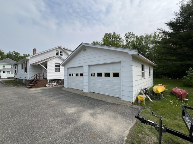 180 Bowdoin St, Millinocket, ME 04462 - view of side of property with a detached garage, an outbuilding, and a chimney