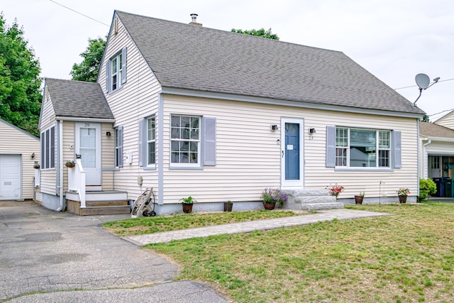 29 Harding St, Biddeford, ME 04005 - view of front of home with an outbuilding, a front yard, roof with shingles, and a garage