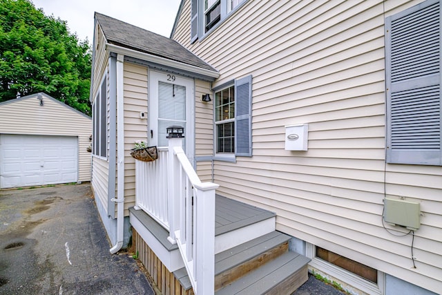 29 Harding St, Biddeford, ME 04005 - doorway to property with roof with shingles, a detached garage, and asphalt driveway