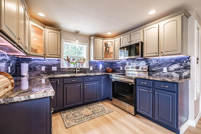 29 Harding St, Biddeford, ME 04005 - kitchen featuring appliances with stainless steel finishes, a sink, light wood-style floors, blue cabinetry, and decorative backsplash