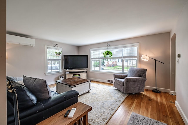 29 Harding St, Biddeford, ME 04005 - living room featuring an AC wall unit, wood finished floors, and baseboards