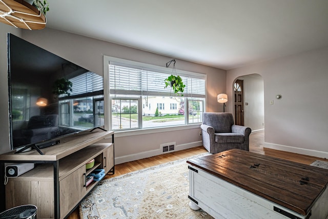 29 Harding St, Biddeford, ME 04005 - living area with arched walkways, baseboards, and light wood-style flooring