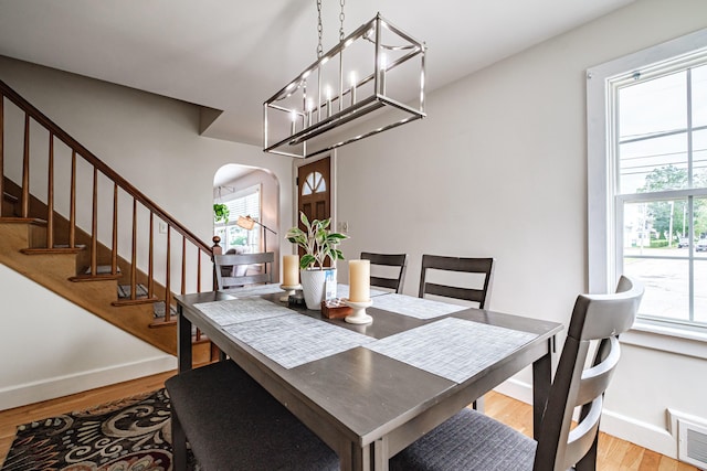 29 Harding St, Biddeford, ME 04005 - dining space featuring arched walkways, baseboards, light wood-type flooring, and stairway