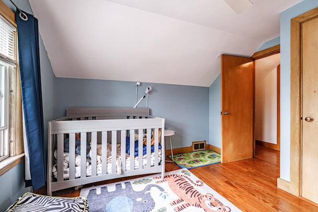29 Harding St, Biddeford, ME 04005 - bedroom featuring vaulted ceiling, wood finished floors, multiple windows, a nursery area, and baseboards
