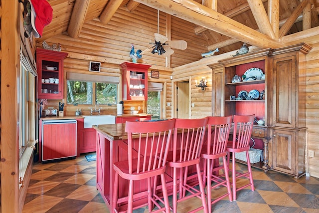 41 Canal St, Grand Lake Stream Plt, ME 04668 - kitchen with dishwasher, a sink, dark flooring, rustic walls, and wood ceiling with exposed beams
