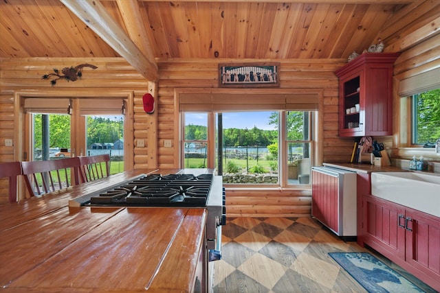 41 Canal St, Grand Lake Stream Plt, ME 04668 - kitchen with stainless steel gas stove, log walls, a sink, wood ceiling with exposed beams, and glass insert cabinets