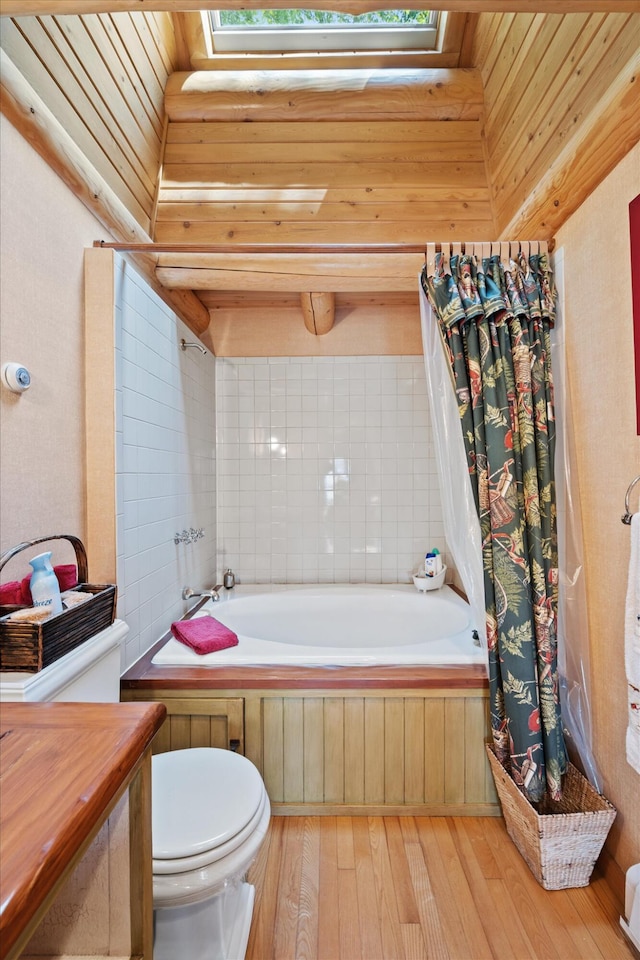 41 Canal St, Grand Lake Stream Plt, ME 04668 - bathroom featuring toilet, hardwood / wood-style flooring, a skylight, shower / bathtub combination with curtain, and vanity