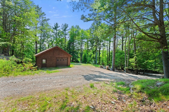 41 Canal St, Grand Lake Stream Plt, ME 04668 - detached garage with driveway and a wooded view